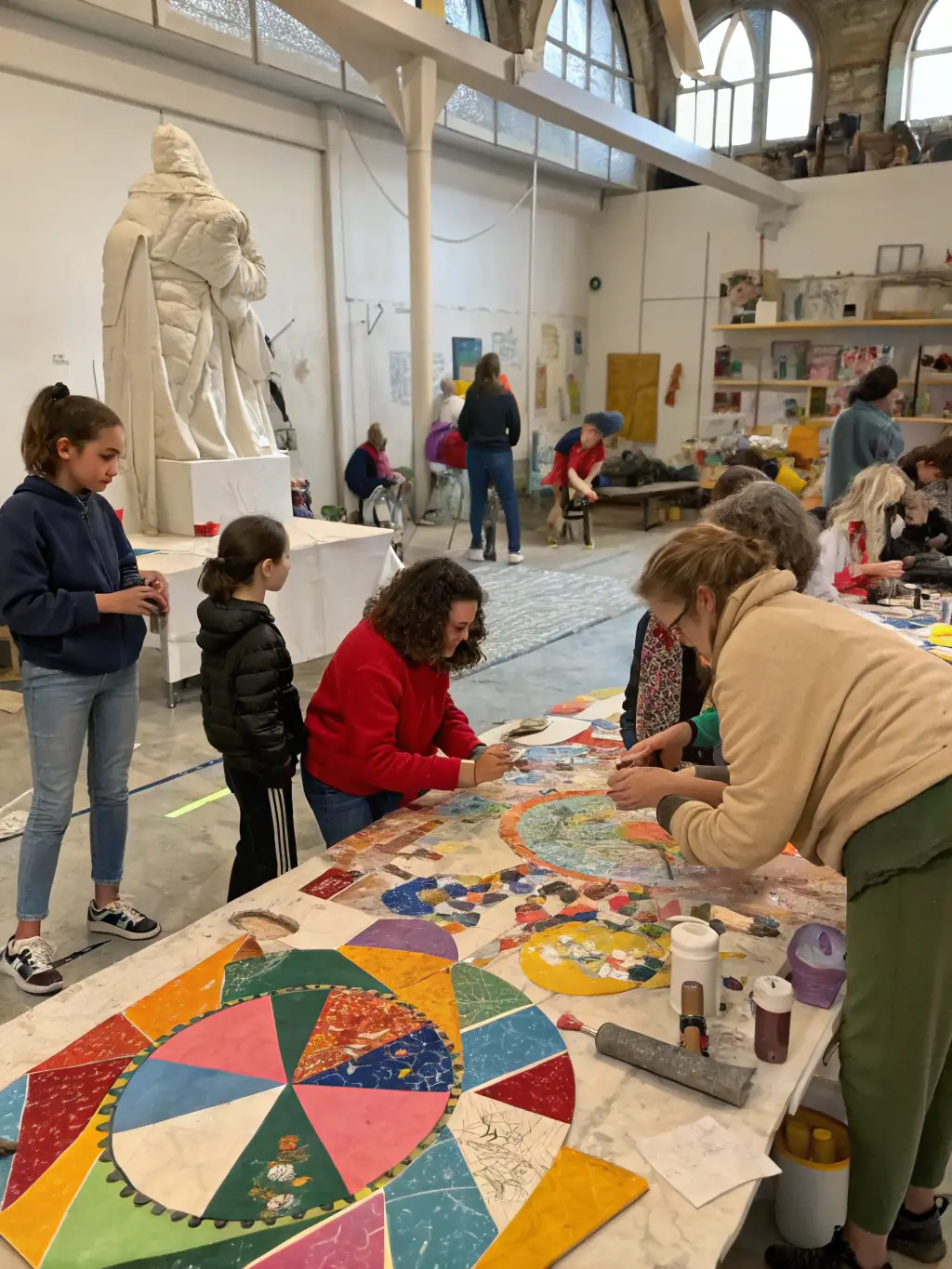 A vibrant photograph capturing a community art workshop in progress, showcasing participants of diverse ages and backgrounds engaged in painting and creative expression, reflecting ASSOCIATION TATINIASS's commitment to inclusive arts engagement.